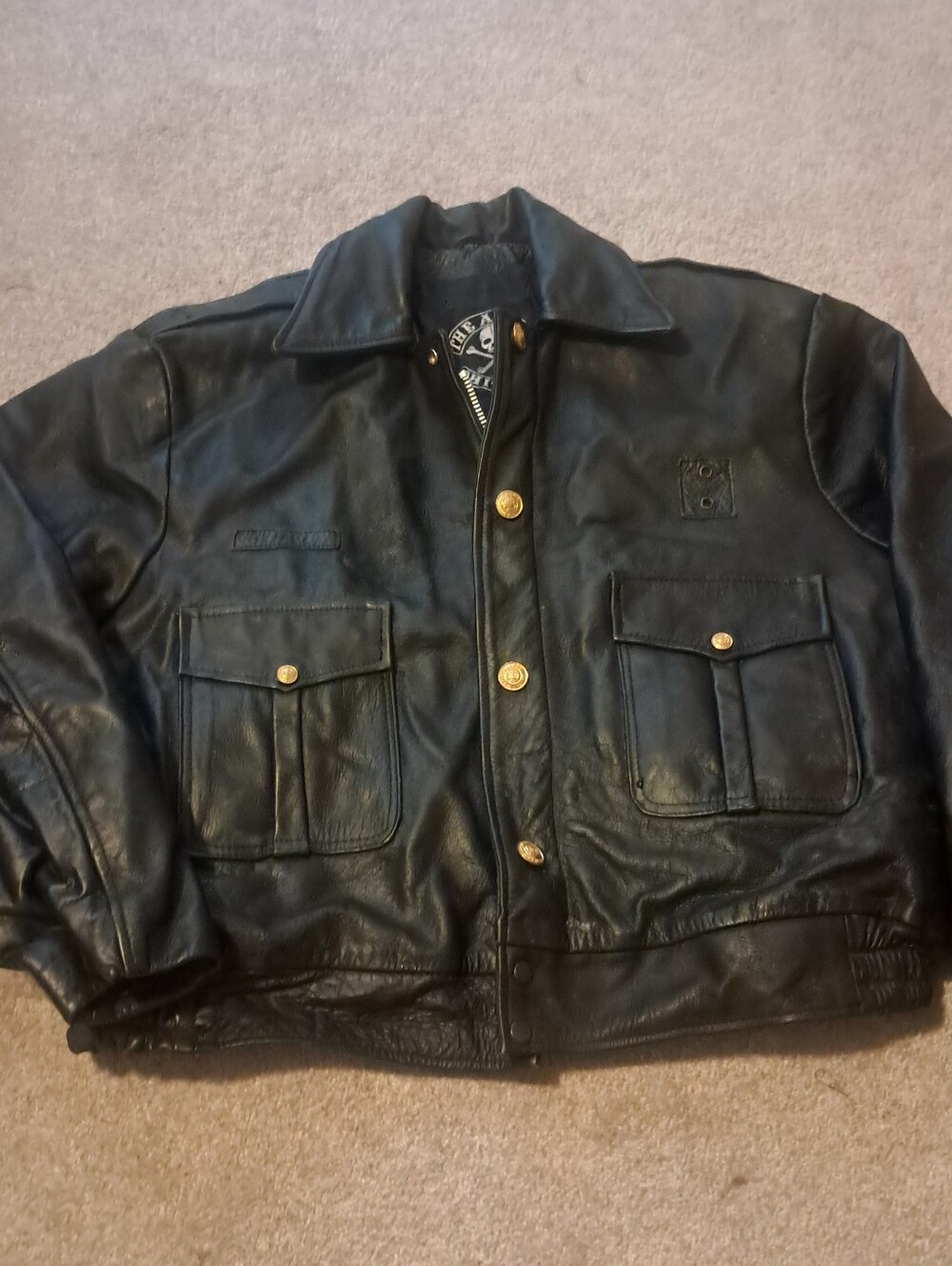 Vintage The Alley Chicago black leather jacket with skull and crossbones logo.